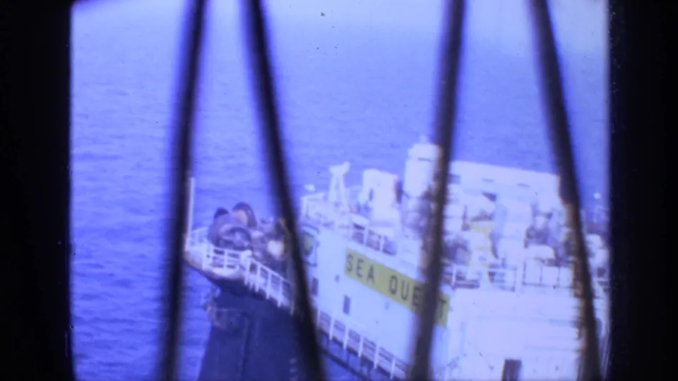1970 United Kingdom 8mm frame showing the SEA QUEST vessel at sea, partially blocked by dark bars and faded blue color.