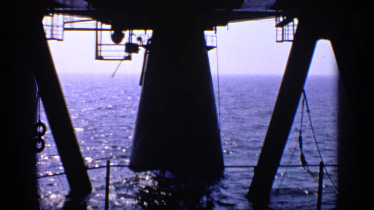 Dark platform supports frame a view of open ocean below.
