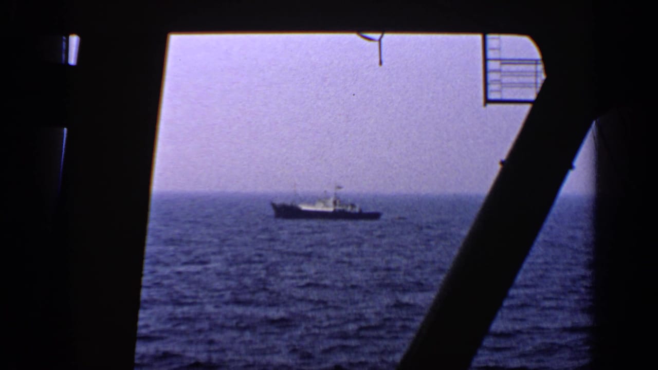Small vessel on open water viewed from inside a ship or platform structure.