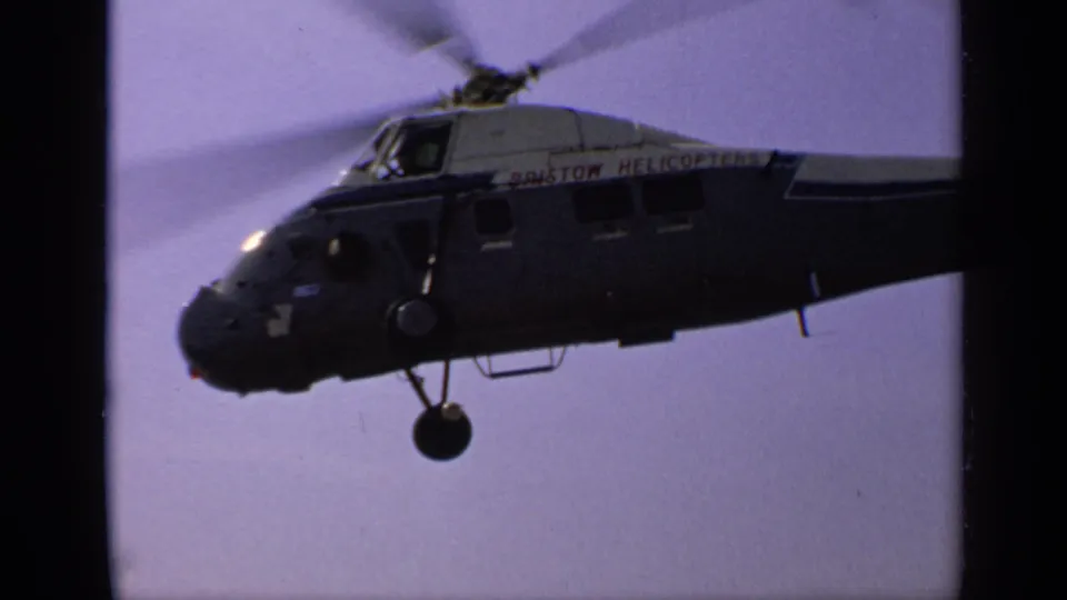 1970 United Kingdom 8mm still showing the helicopter banking or passing close, with Bristol lettering partly visible.