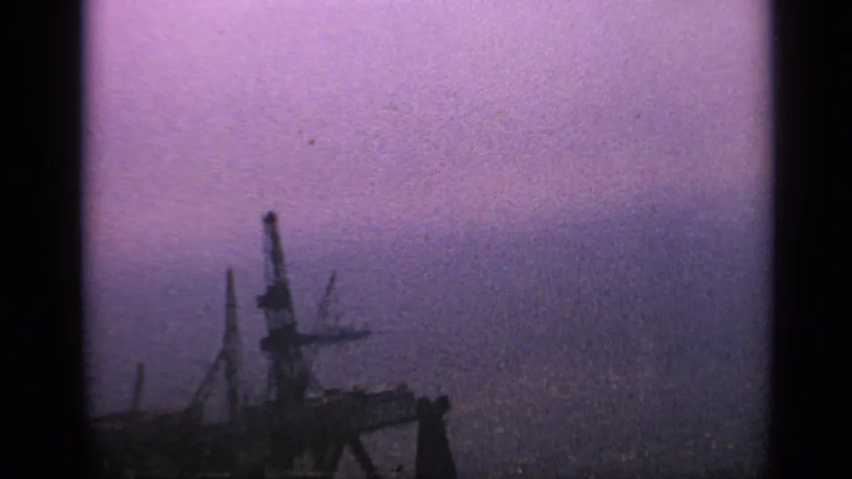 1970 United Kingdom 8mm frame with the platform lower in view, surrounded by open sea and purple atmospheric haze.