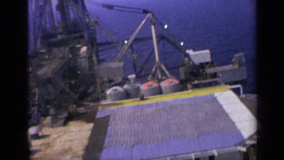The final frame holds on the offshore rig deck, showing cranes, tanks, lights, and a roofed structure beside the sea.