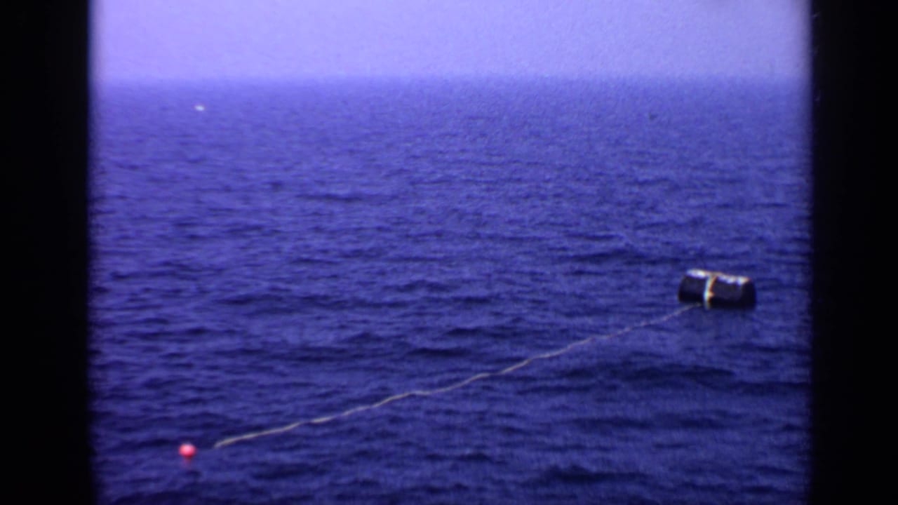 Buoy and line on the ocean surface, with a small red marker buoy nearby.
