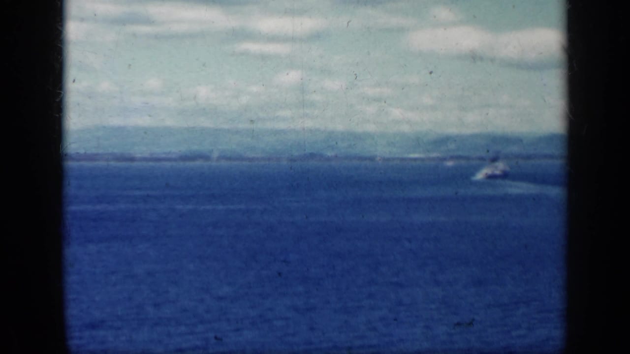 Blue ocean and distant shoreline seen through dark 8mm frame borders.