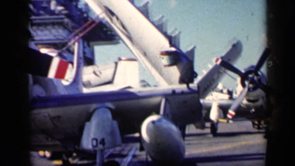 The 1962 Cuba clip shows parked naval aircraft with folded wings and propellers, filmed close to the carrier deck surface.