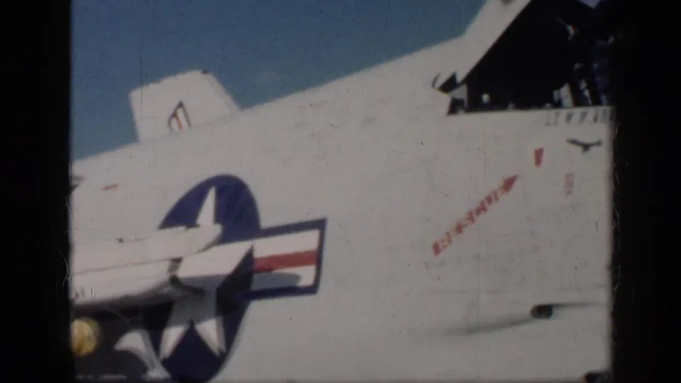 U.S.-marked jet fuselage fills the frame, showing the star insignia, red stenciling, and the raised cockpit area near the edge.