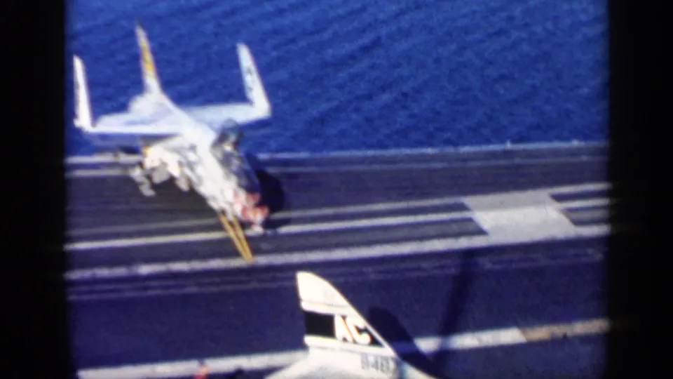 High-angle 1962 catalog view near Cuba of a jet seen from behind on an aircraft carrier deck, with sea in the background.
