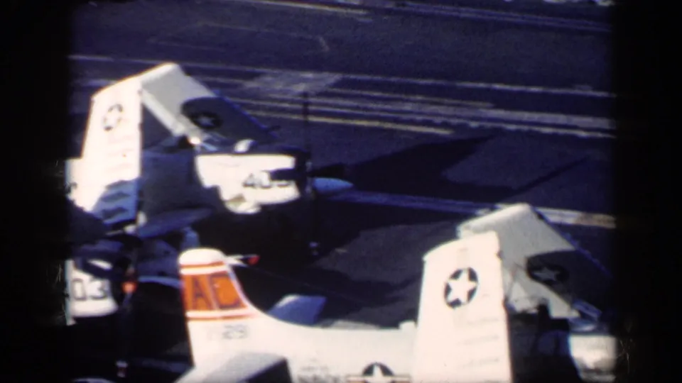 1962 carrier-deck footage near Cuba showing U.S. military aircraft tails, folded wings, and visible insignia on the flight deck.