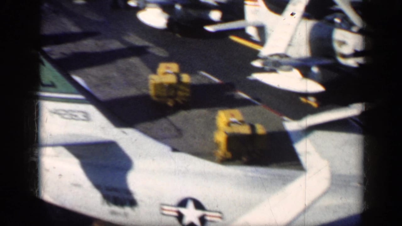 Parked military aircraft wing and tail sections with U.S. star insignia on a sunlit tarmac.