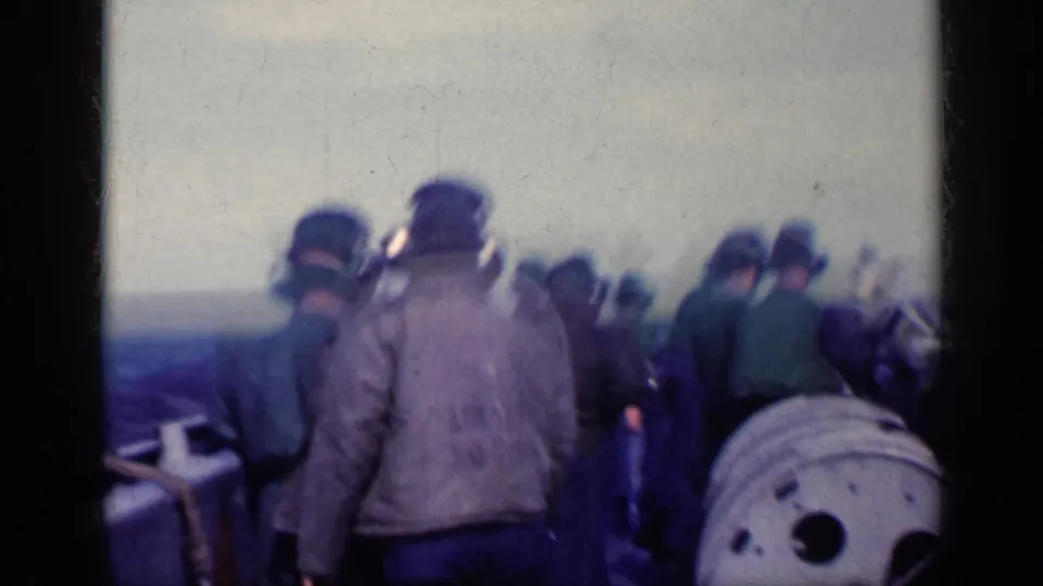 1962 Cuba metadata supports this deck-level view of U.S. Navy personnel in headsets gathered near flight deck equipment.