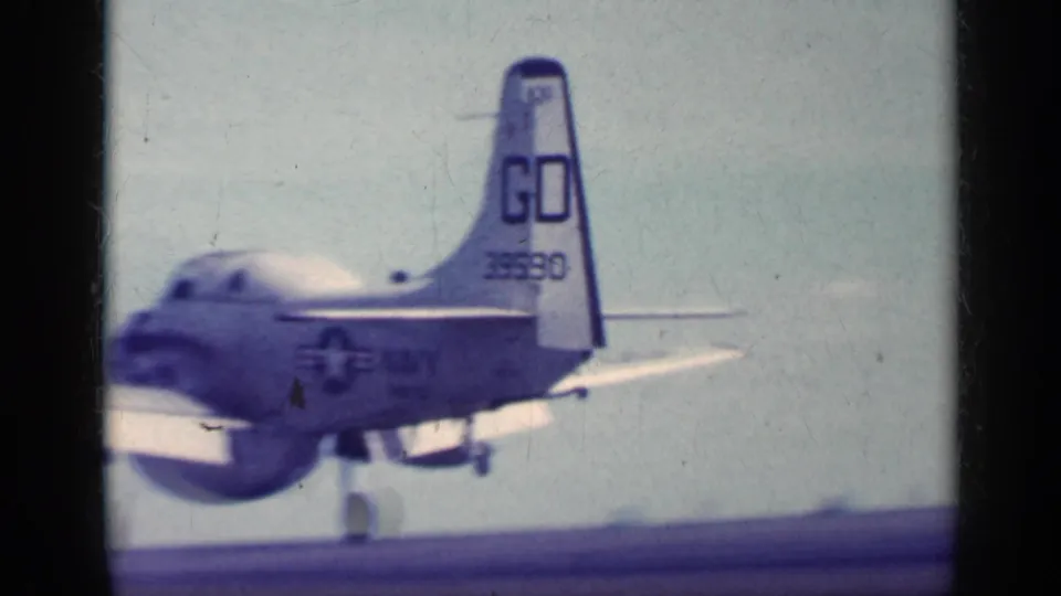 A U.S. Navy aircraft with visible tail and service markings sits or moves on the flight deck in 1962 Cuba metadata context.