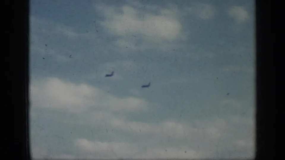 Two distant jets appear against a cloudy sky in 1962 Cuba-labeled 8mm home-movie footage.