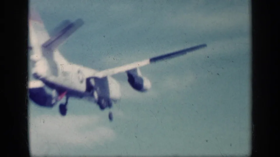 1962 Cuba 8mm frame showing a commercial airliner passing close overhead with gear down during approach.