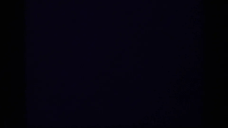 Dark 8mm frame from the 1962 Cuba clip, likely from blocked or misexposed footage, with only a faint blue band visible.