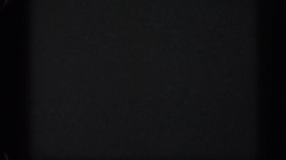 A nearly black, soft 8mm frame from the 1962 Cuba home movie, showing film texture but almost no scene detail.