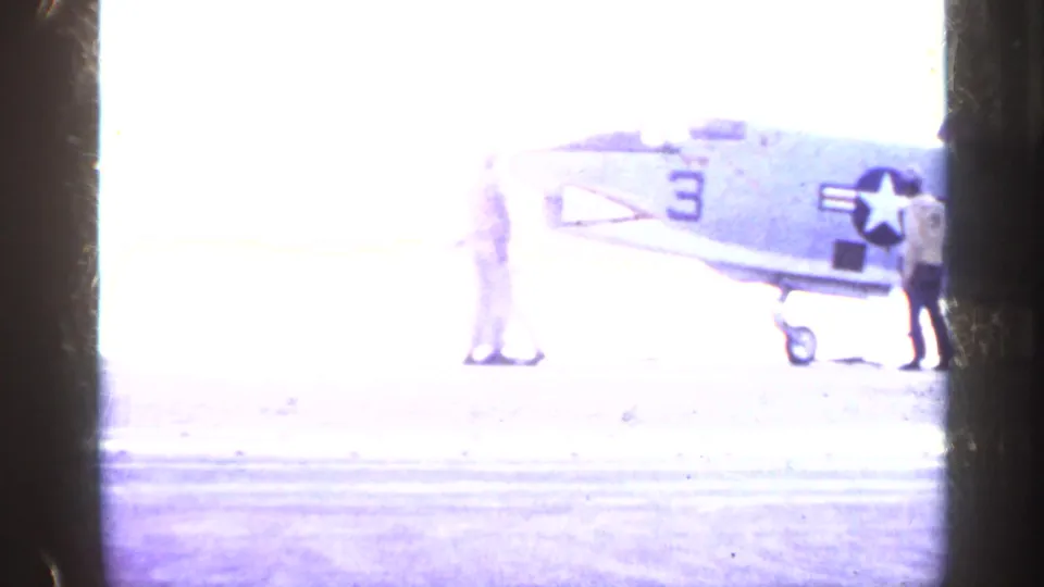 1962 Cuba metadata frame showing a U.S. Navy jet marked number 3 on a carrier deck, with crew partly washed out by bright exposure.