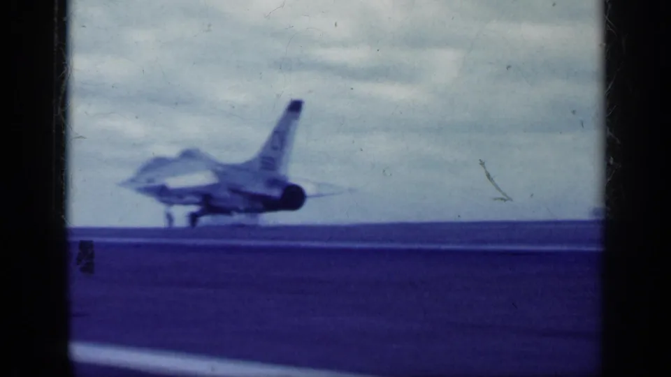 A military jet appears farther down the deck or runway in blue-tinted 1962 Cuba-associated 8mm footage.