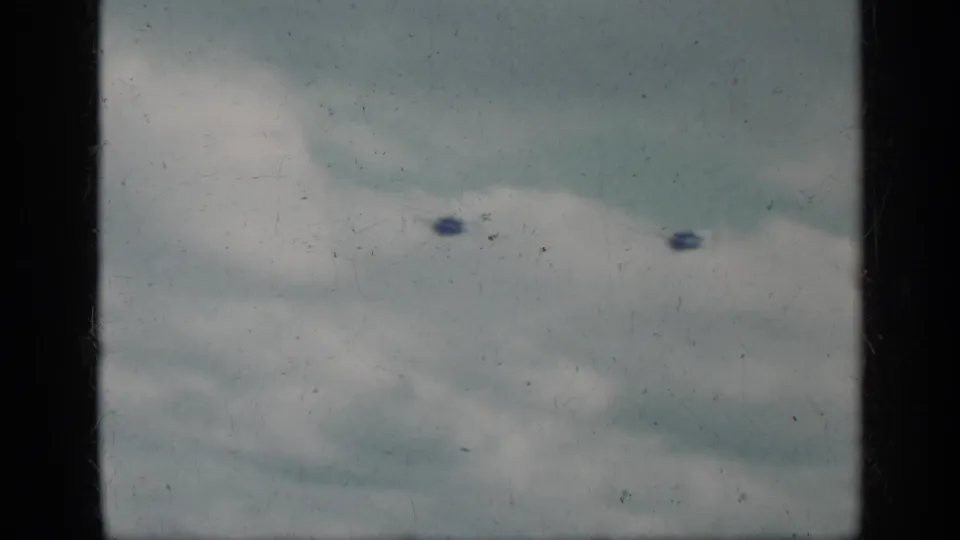 Cuba 1962 8mm frame with cloudy sky and several small dark aircraft-like shapes or marks seen from a shipboard position.