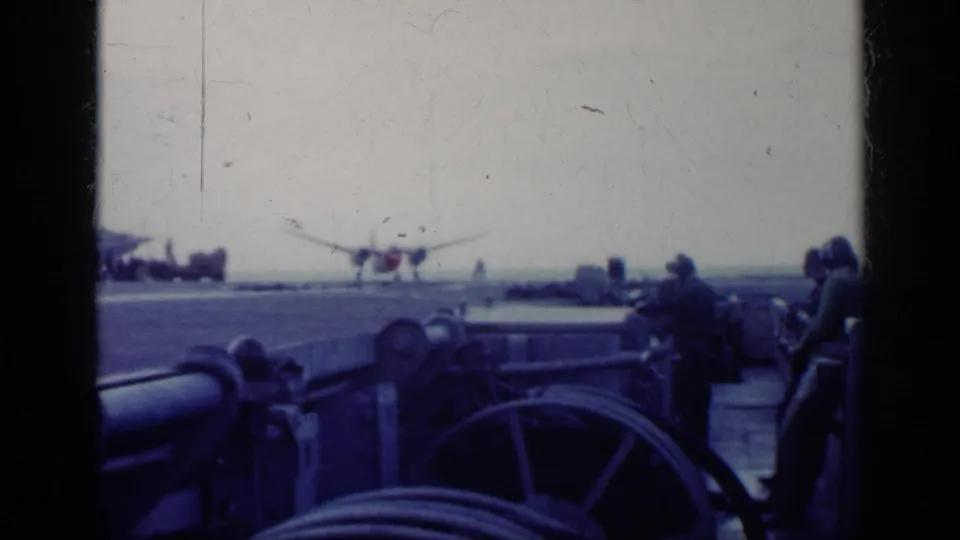 Cuba 1962 8mm frame showing an aircraft near the deck area, with people, railings, and shipboard equipment in the foreground.