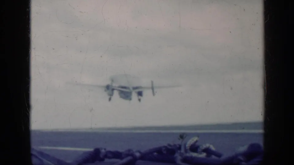Aircraft appears airborne beyond the carrier deck in blue-tinted 8mm footage tied to the supplied Cuba 1962 clip metadata.