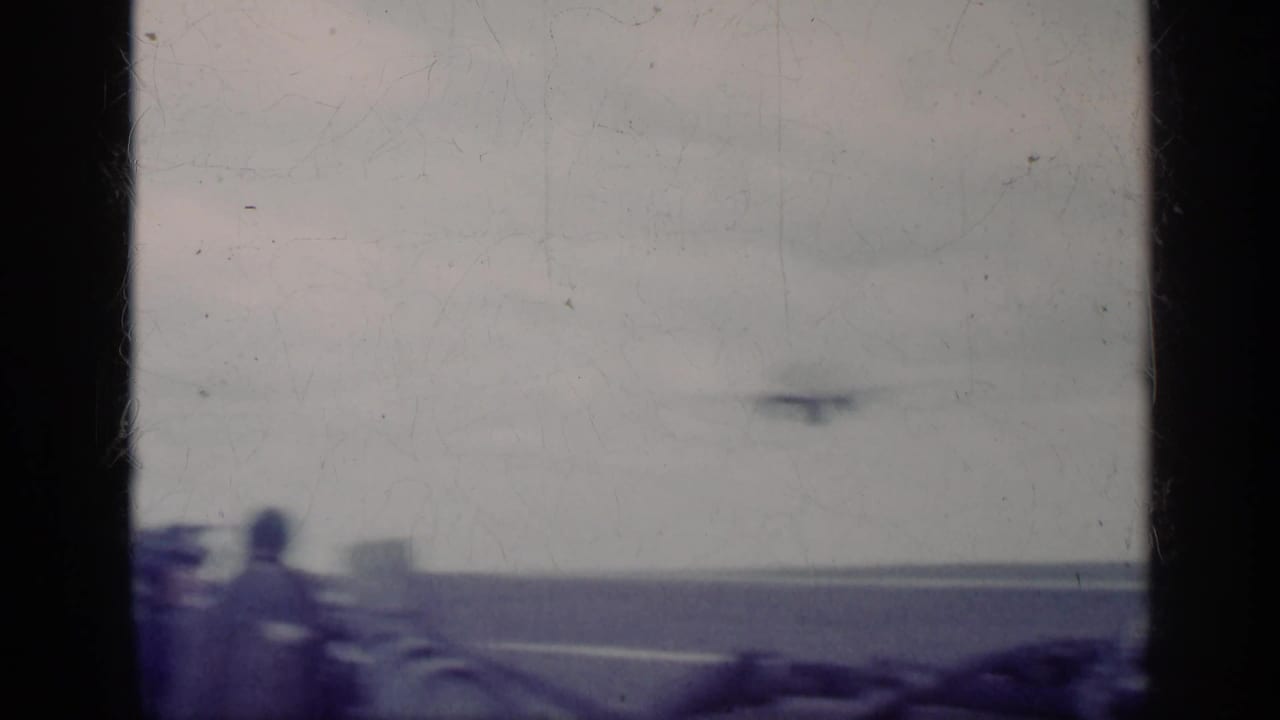 Soft, overexposed 8mm frame from the Cuba 1962 clip showing a carrier deck, horizon, and indistinct aircraft movement.