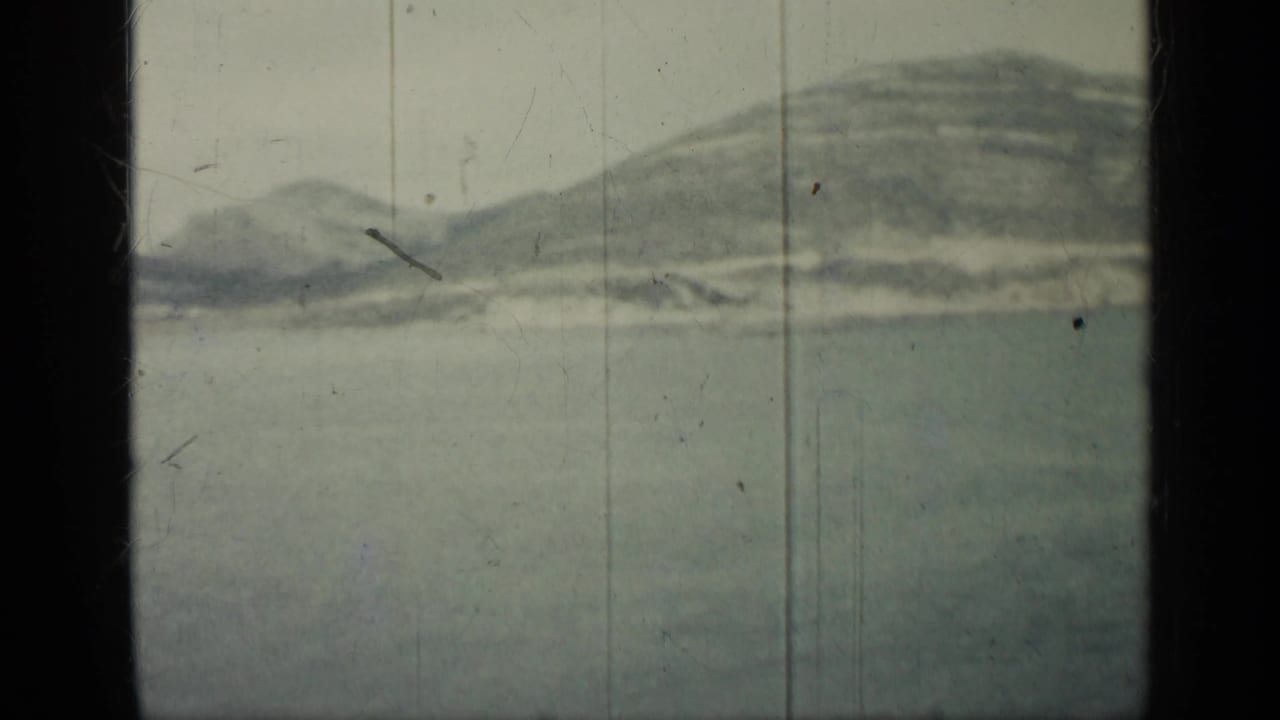 Hazy hills and calm water seen through 8mm film frame edges.