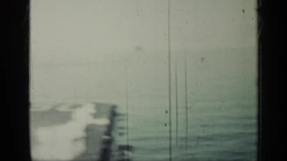 Soft 1962 Cuba-linked 8mm view of an aircraft carrier deck area and ocean, with heavy frame borders and film scratches.