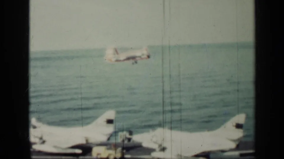 The frame shows an aircraft over the sea and a partial carrier deck foreground, consistent with the Cuba 1962 naval aviation metadata.