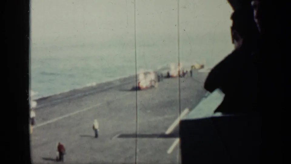 Final 8mm frame of the 1962 Cuba-linked ship deck view, with distant personnel and a strong dark silhouette at right.