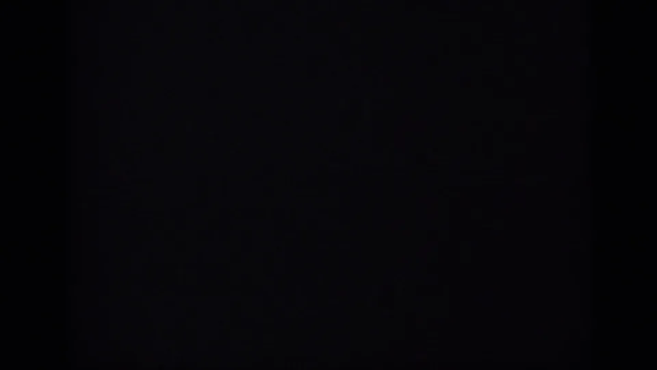 Dark opening frame from archival 8mm footage, with the scene largely obscured by black frame masking.