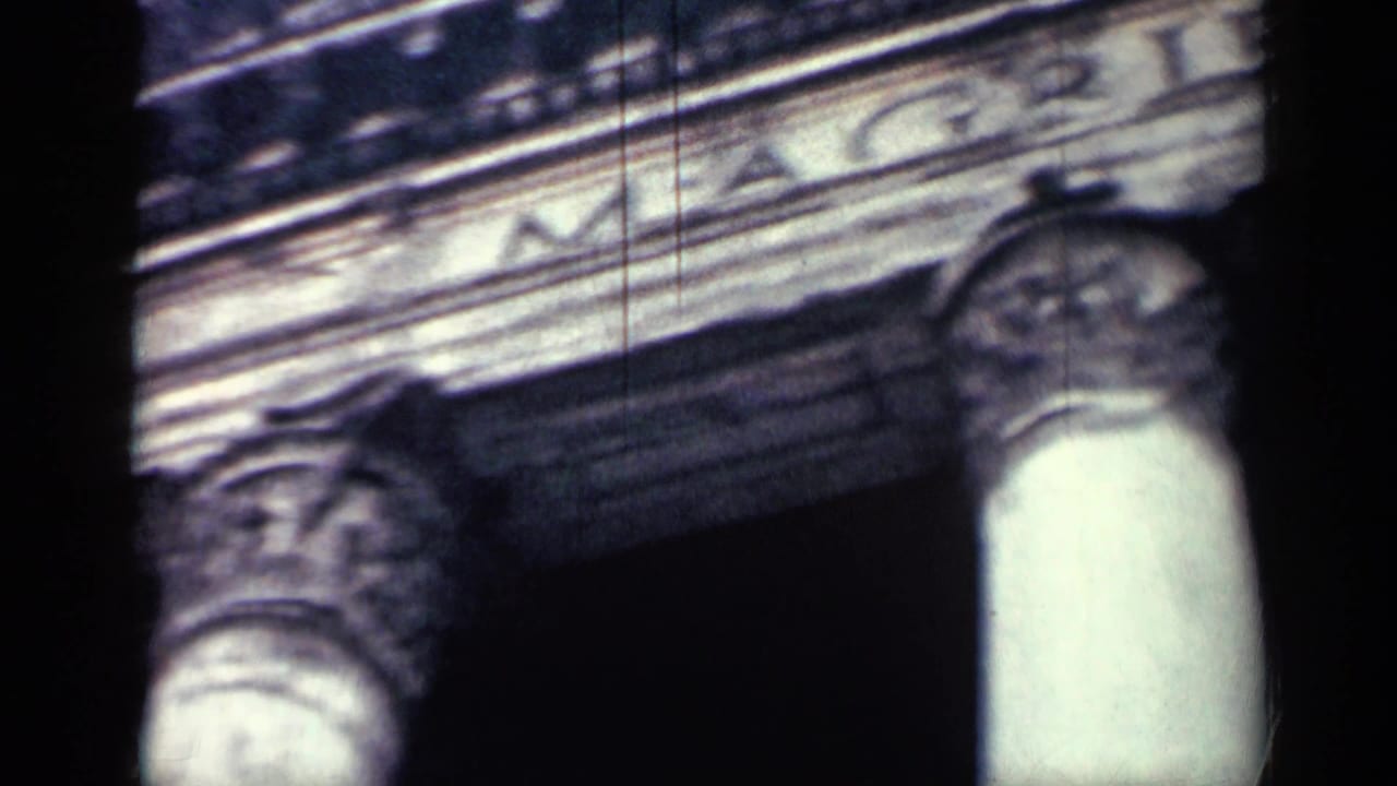 Close 8mm view of carved stone fountain detail in Cuba, with soft focus, dark gate edges, and visible film grain.
