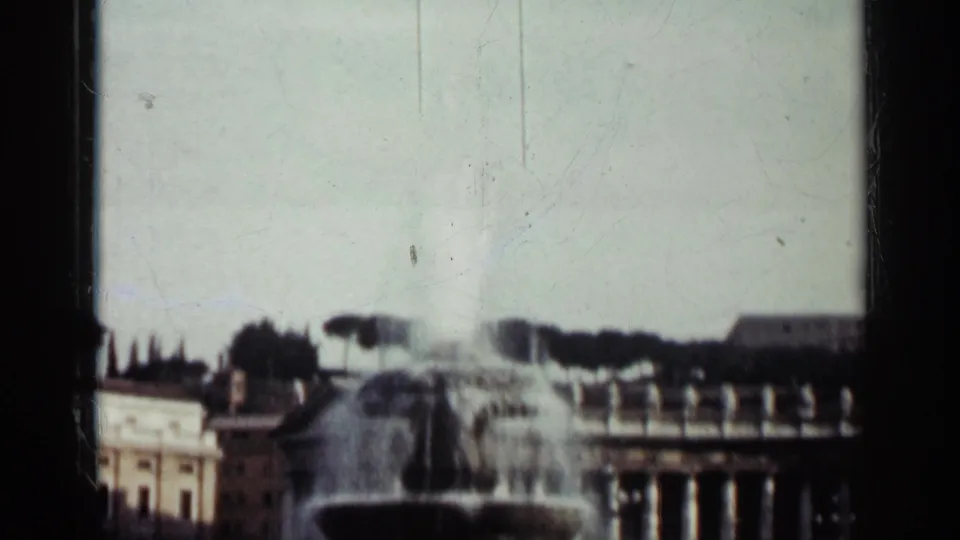 Faded 1962 Cuba 8mm frame showing the fountain and plaza buildings through soft exposure and visible film wear.