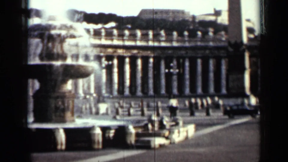 1962 Cuba 8mm wide frame of the public square, with the fountain at left and a columned building across the plaza.
