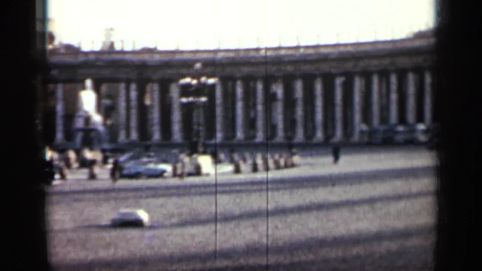 A 1962 Cuba street view shows a classical colonnade, vintage automobiles, cobblestones, and heavy dark foreground obstruction.