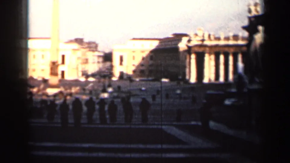 1962 Cuba 8mm frame with bright classical buildings, statues, an obelisk-like vertical monument, and a dark foreground edge.