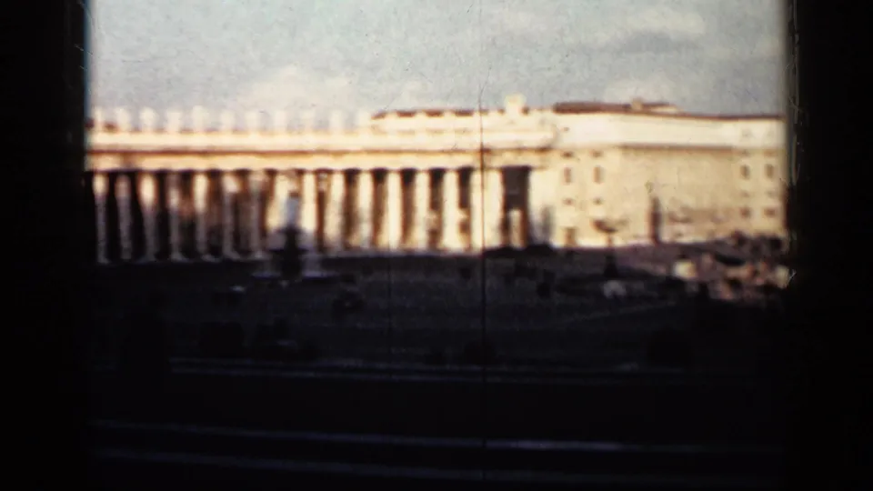 1962 Cuba 8mm view of a long classical colonnade and adjoining palace-like building beyond a shadowed public space.