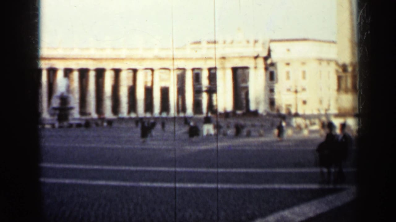 Wide plaza view with colonnade, distant pedestrians, and surrounding classical buildings.