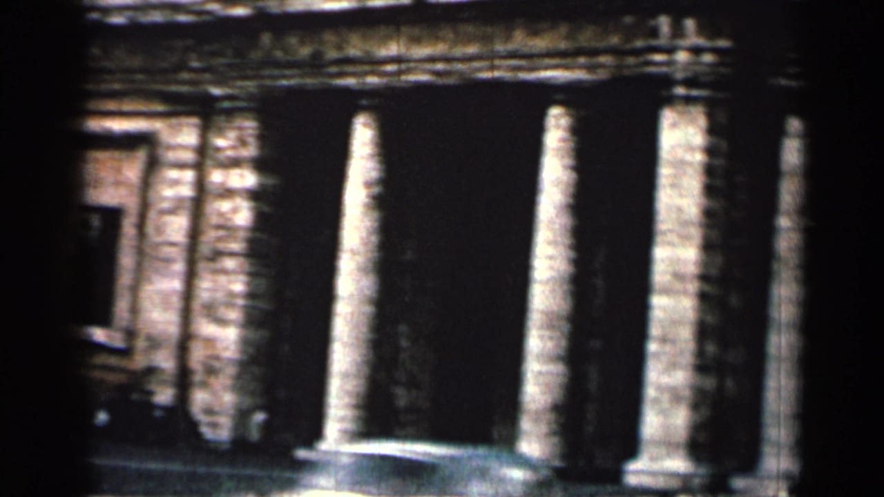 Close view of stone pillars and a shadowed entrance on a heritage-style building.