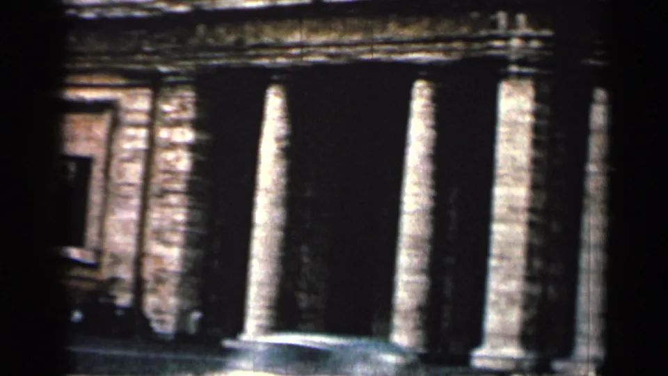 1962 Cuba 8mm frame showing tall stone pillars, a dark doorway, and weathered classical facade details.