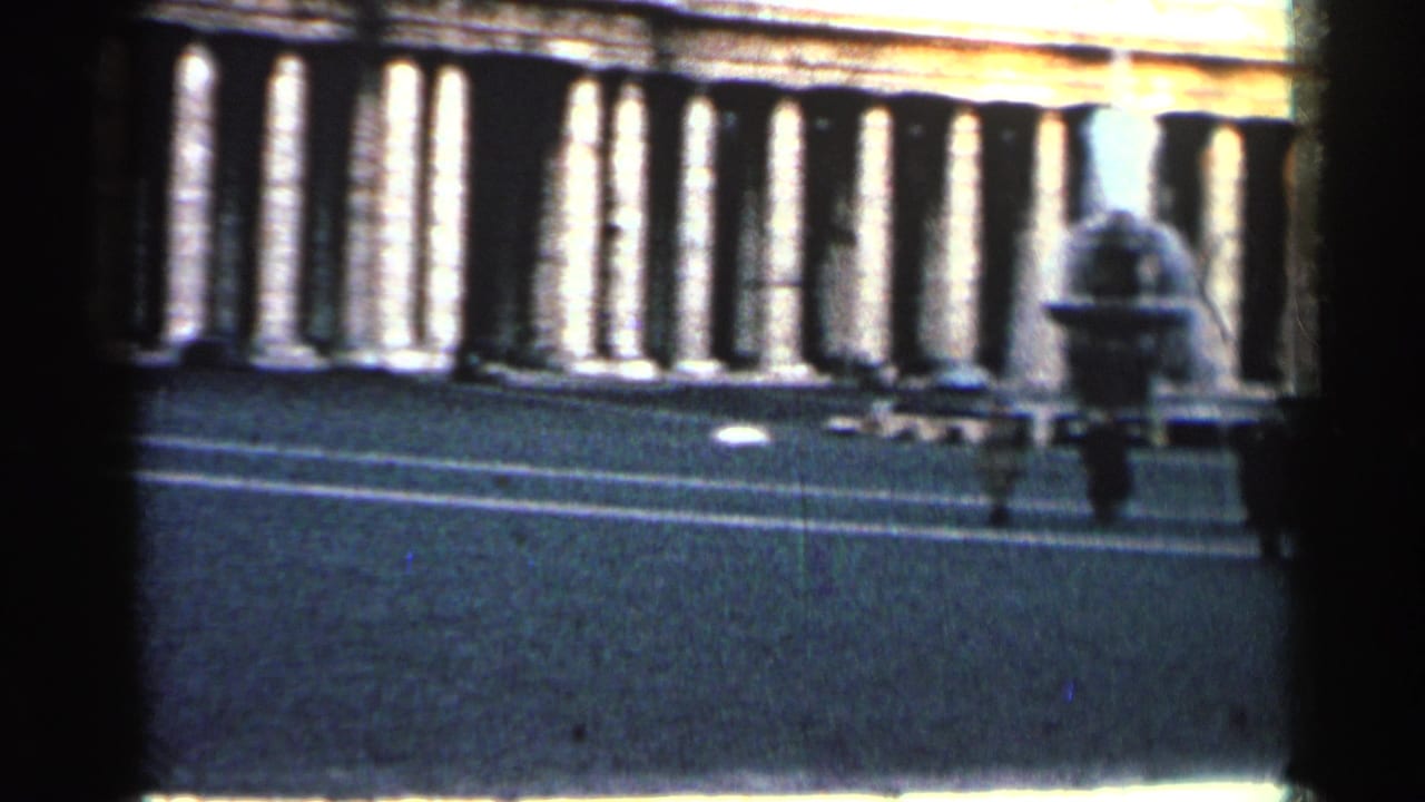 Dark 8mm frame showing a carrier deck edge, railings, and a distant crew figure.