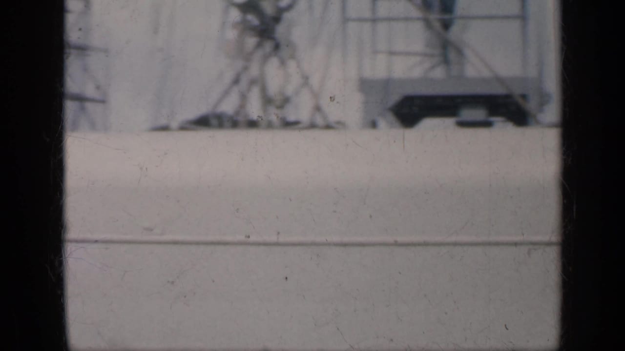 1962 Cuba-associated 8mm frame looking past white ship railings and structure toward a hazy blue ocean horizon.