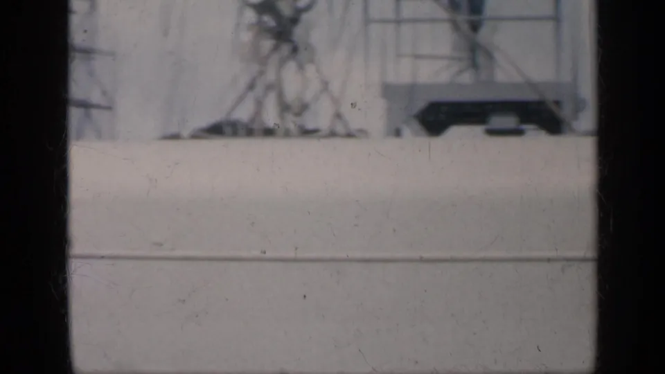 1962 Cuba-associated 8mm frame looking past white ship railings and structure toward a hazy blue ocean horizon.