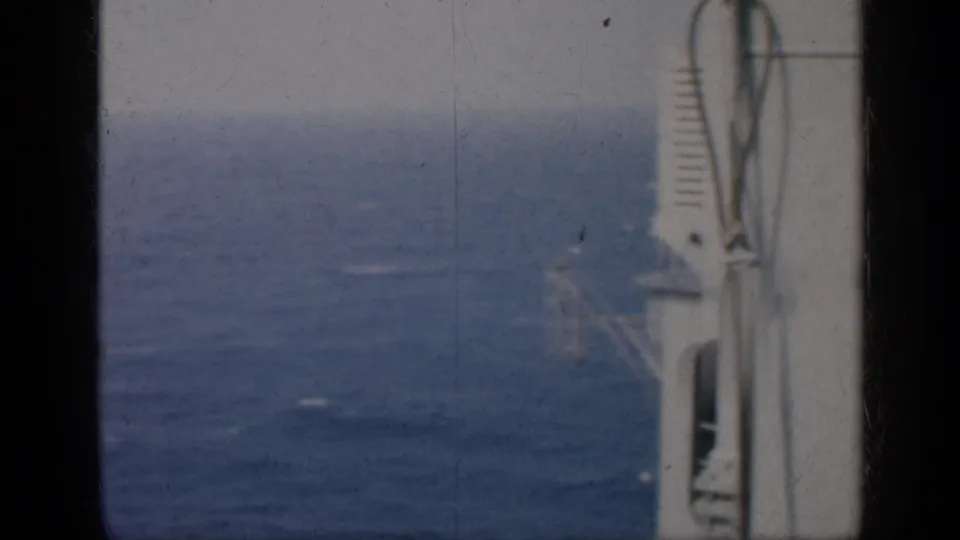 1962 Cuba-associated 8mm frame with open blue water, a white vessel edge, railings, and visible film wear.