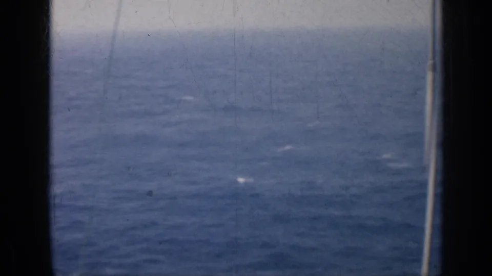 1962 Cuba 8mm frame showing open blue ocean, a soft horizon, and dark ship-window or film-edge framing.