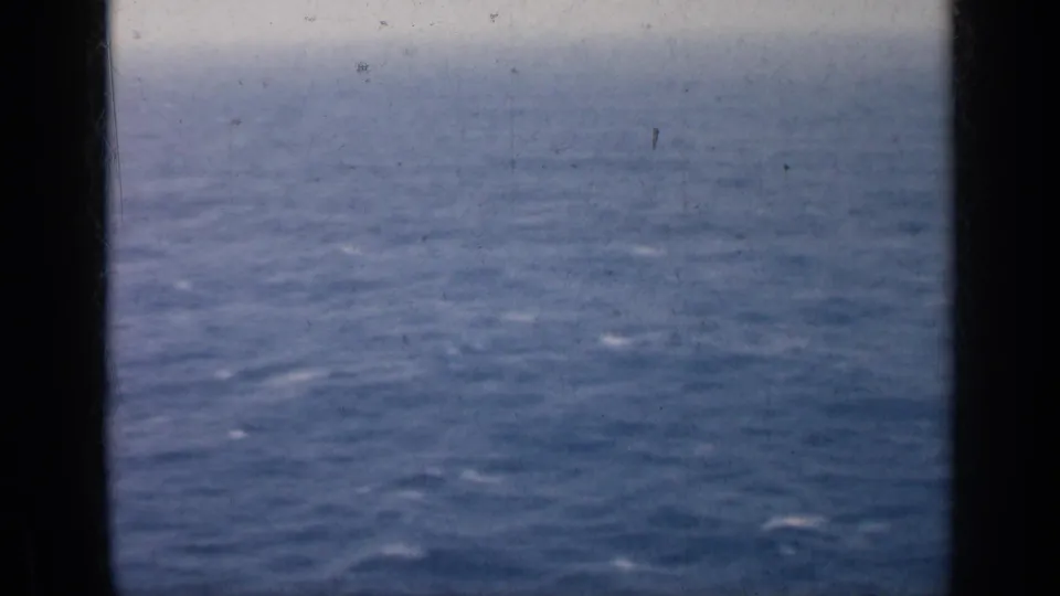 1962 Cuba 8mm frame of choppy ocean water and a pale horizon, partly obscured by a dark central ship or film border.