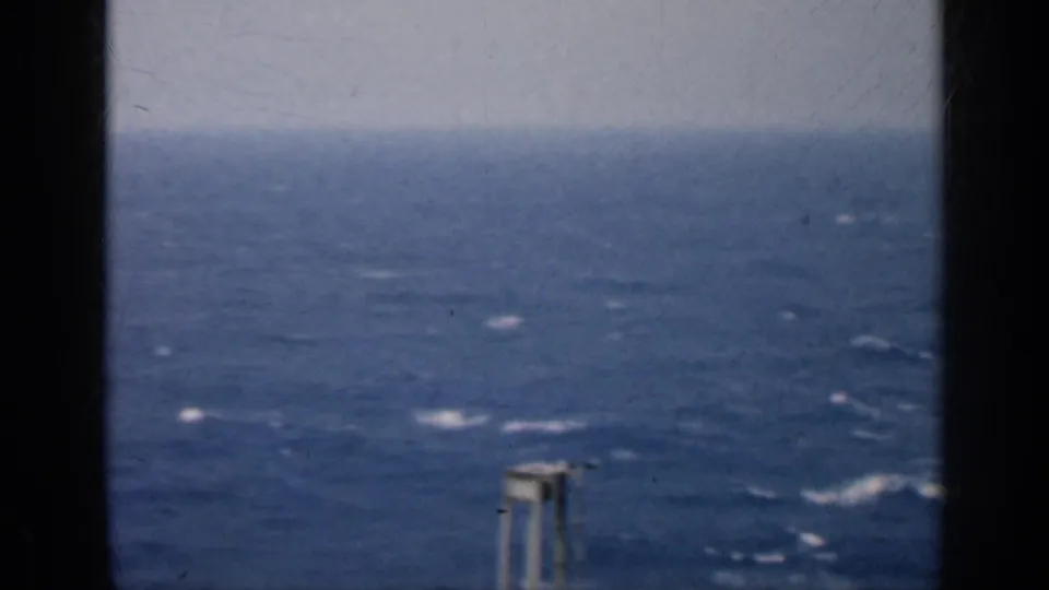 1962 Cuba 8mm frame showing blue choppy water, whitecaps, and a pale tower-like structure briefly visible near the lower frame.