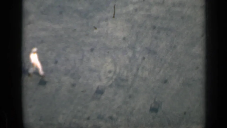 A distant worker in light clothing crosses the dark deck surface in the Cuba 1962 shipboard footage.