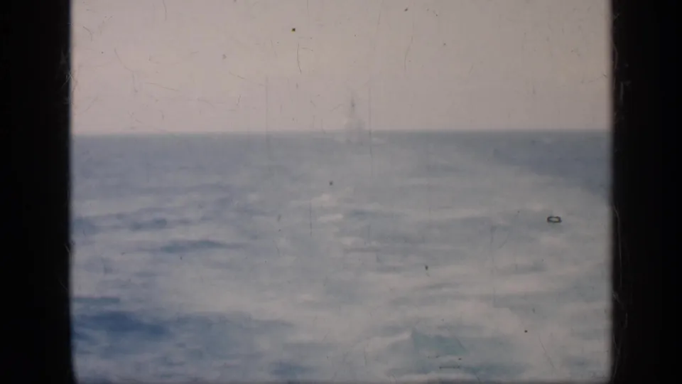 1962 Cuba 8mm home-movie view of rough sea beneath cloudy light, with dark window framing and visible film wear.