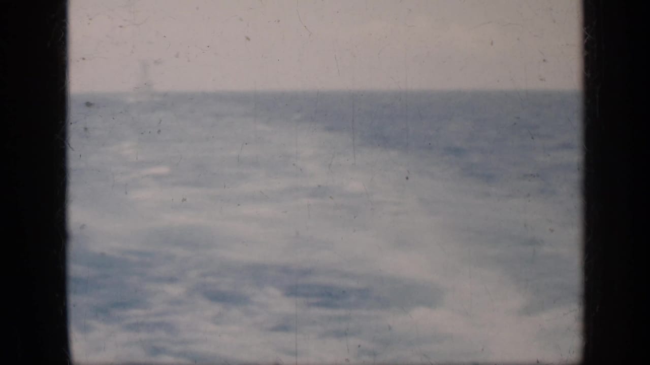 Choppy ocean and pale sky seen through dark 8mm frame edges.