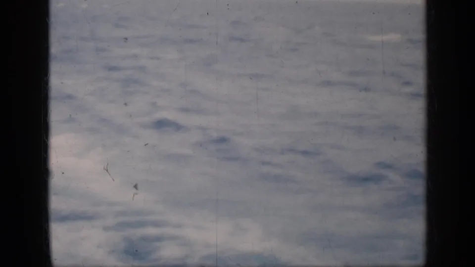 1962 home-movie frame showing blue-gray choppy water from a moving boat, with visible 8mm borders and dust.